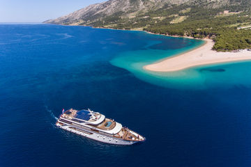 A small cruise boat sailing around Golden Horn Beach (Split, Croatia)